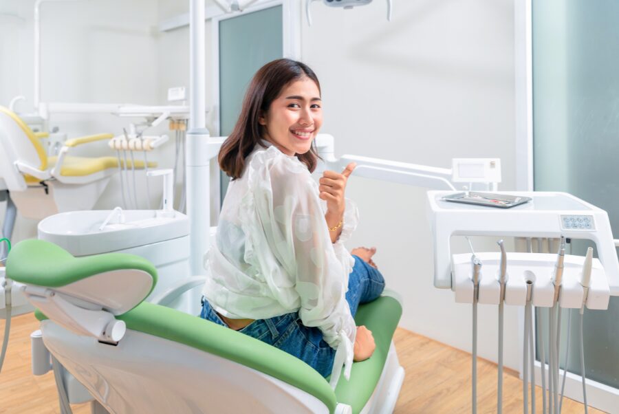 Smiling adult using home teeth whitening kit in Alexandria VA